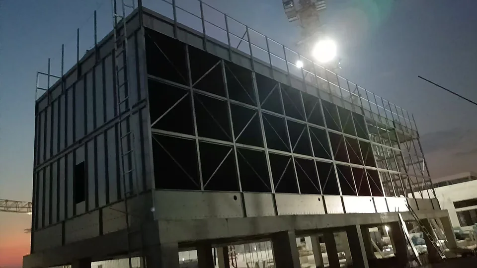 Cooling tower structure photographed during evening site work